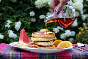 pouring maple syrup on pancakes